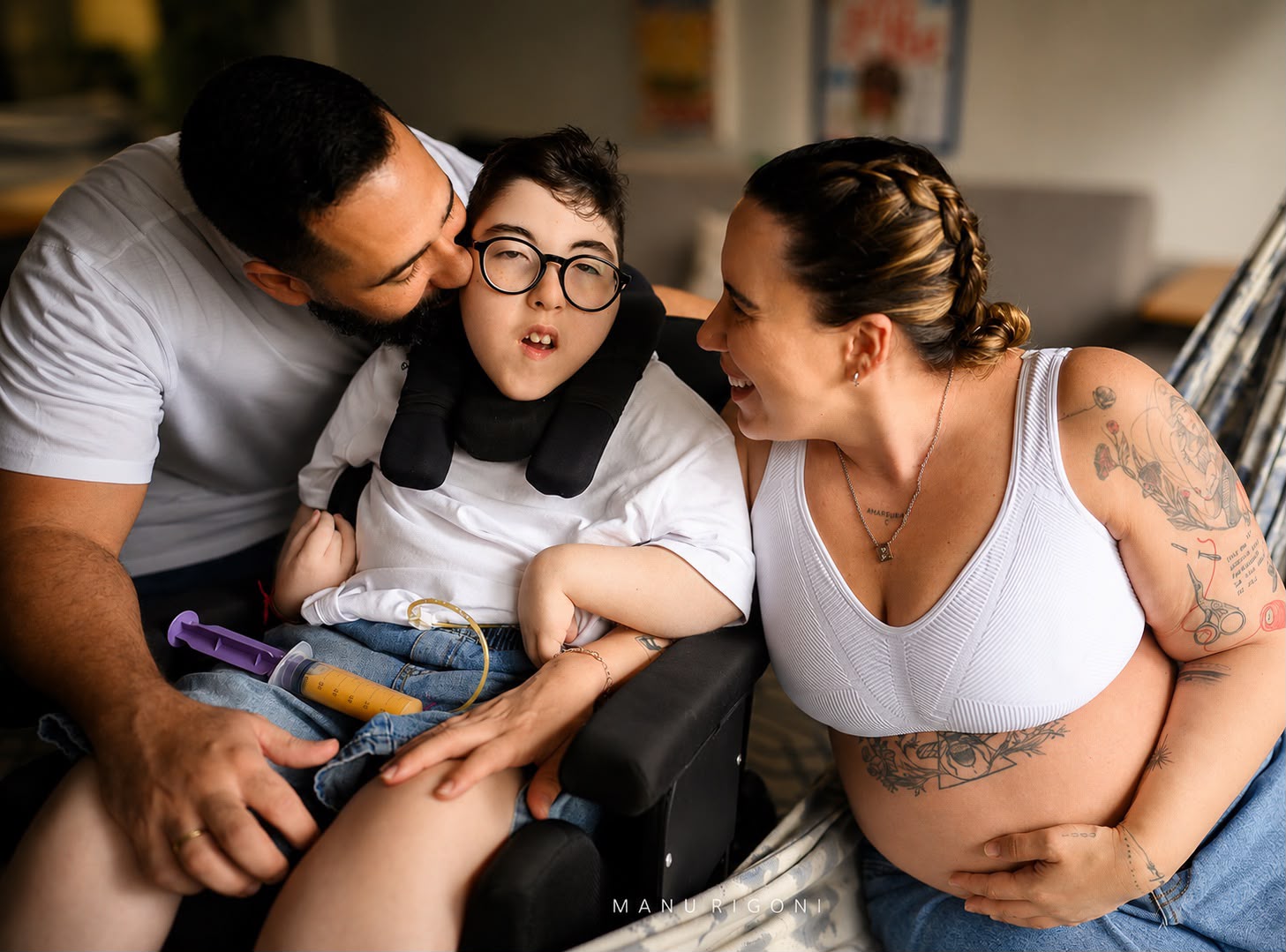 Família cuidando de filho com deficiência, mãe grávida ao lado